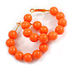 Medium Size Orange Acrylic Bead Hoop Earrings in Gold Tone - 40mm Diameter